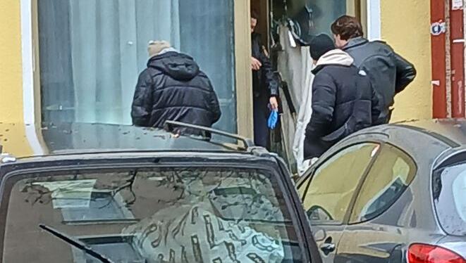 Polizisten sichern Spuren hinter der zerstörten Eingangstür.