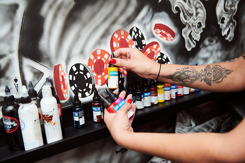 Rot und schwarz an der Wand - und viele bunte Tattoofarben.