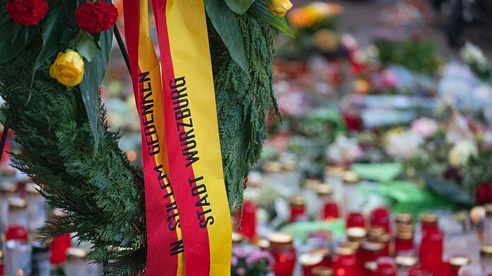 Trauerkerzen und Blumen, sowie ein Kranz der Stadt Würzburg, liegen am Tatort.