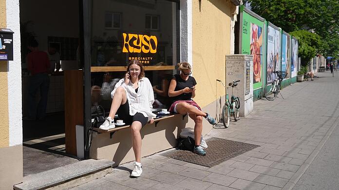Anna (l.) und Catharina trinken ihren Kaffee in der Sonne.