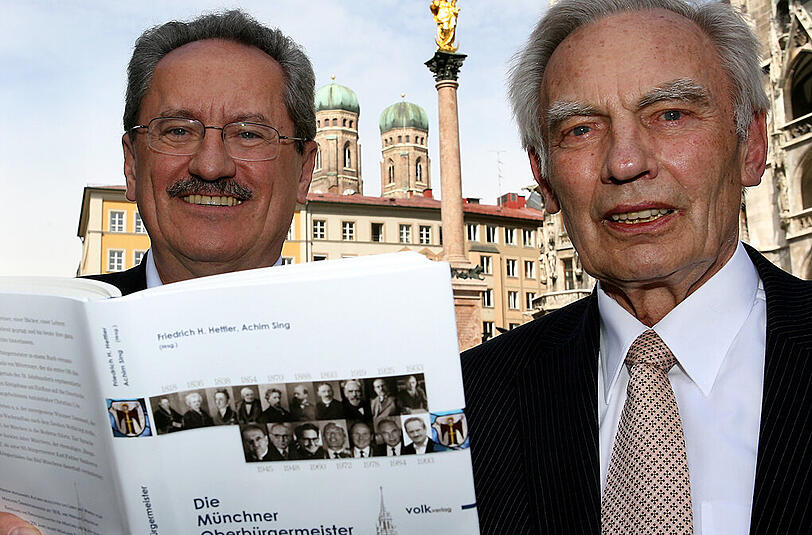 Hier stehen Georg Kronawitter und Christian Ude im April 2008 mit einem Buch über die Münchner Oberbürgermeister auf dem Marienplatz in München.