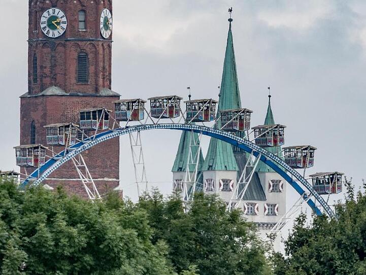 Ein Riesenrad steht auf dem Gelände des Gäubodenvolksfestes vor dem Stadtturm und der Basilika St. Jakob. Foto: Armin Weigel/Archivbild