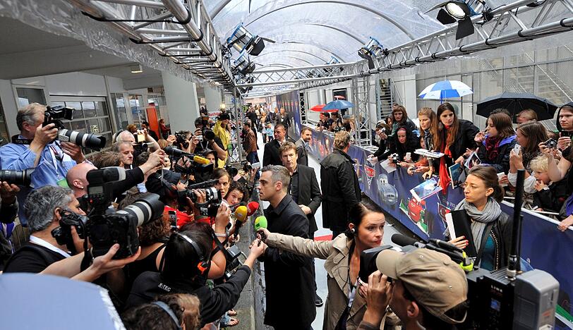 Weltstar im Fan-Gewusel: Robbie Williams verteilte Autogramme vor dem Mathäser-Kino.