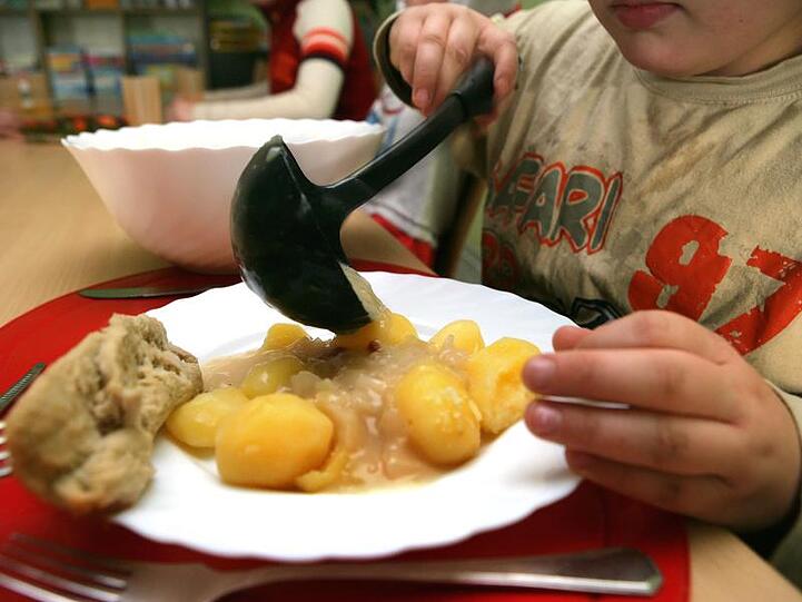 Ein Junge nimmt sich beim Mittagstisch des Kinderschutzbundes in Schwerin Soße für die Kartoffeln.