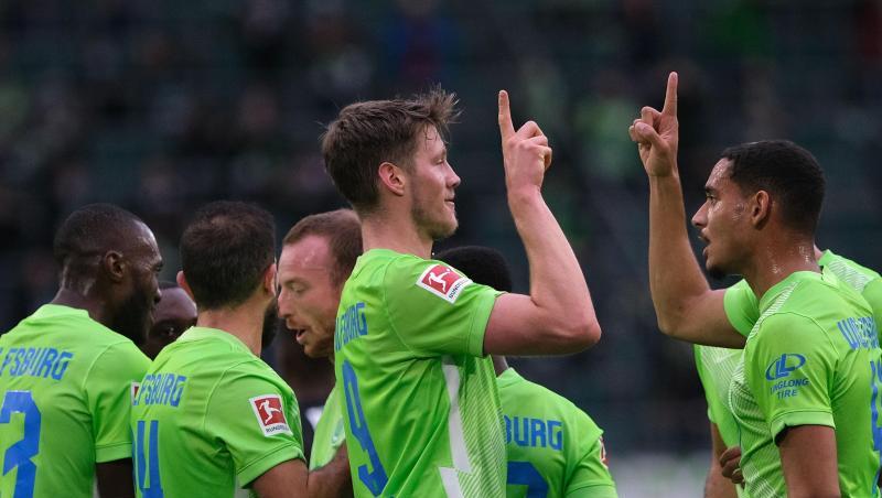 Wolfsburgs Wout Weghorst (M) bejubelt sein Tor zum 1:0 gegen Arminia Bielefeld mit Mannschaftskamerad Maxence Lacroix (r).