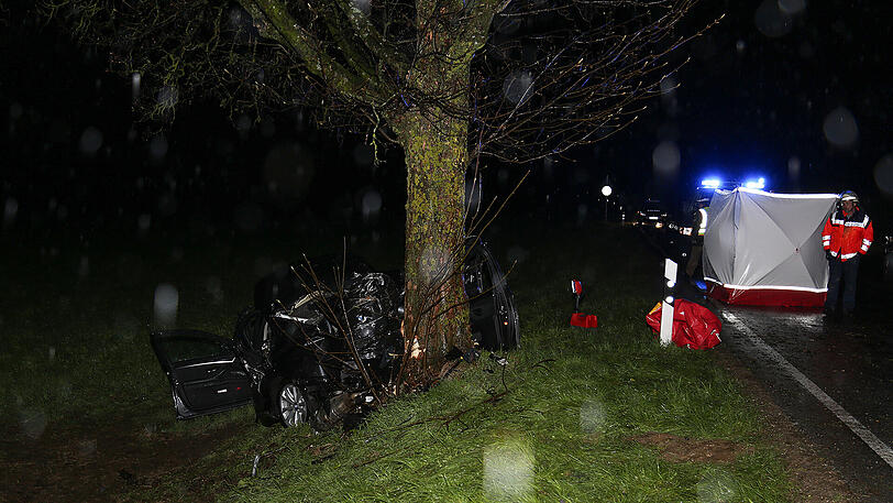 Schreckliche Bilder aus Icking: Der BMW kam von der Straße ab und prallte gegen einen Baum. Zwei 19-jährige Männer starben.