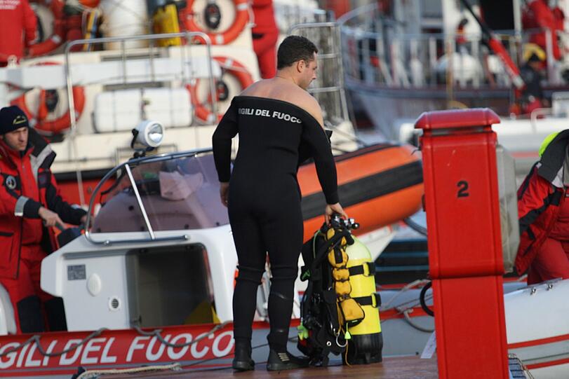 Ein Taucher der italienischen Feuerwehr bereitet sich auf seinen Einsatz vor.