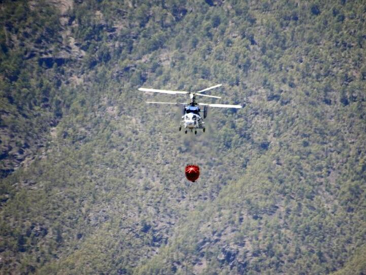 Ein Hubschrauber fliegt zu einem Waldbrand in der Nähe von Artenara.