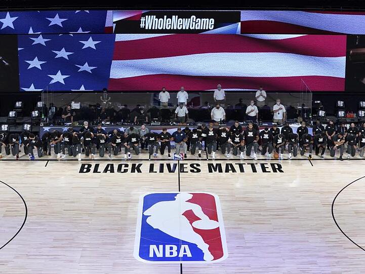 Die Spieler der New Orleans Pelicans und Utah Jazz knien bei der Nationalhymne gemeinsam vor einem "Black Lives Matter"-Schriftzug.