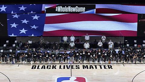 Die Spieler der New Orleans Pelicans und Utah Jazz knien bei der Nationalhymne gemeinsam vor einem "Black Lives Matter"-Schriftzug.