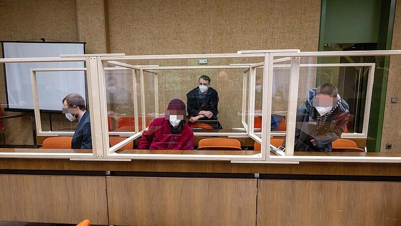 Die drei Angeklagten vor Prozessbeginn: im Hintergrund der Strafverteidiger.