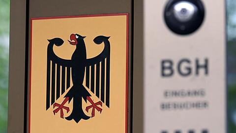 Vor dem Bundesgerichtshof (BGH) hängt ein Schild mit Bundesadler und dem Schriftzug Bundesgerichtshof. Foto: Uli Deck/Archivbild