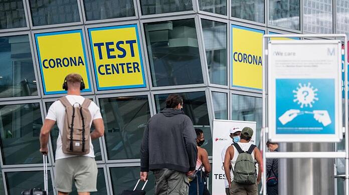 Ankommende Fluggäste gehen zu einem Corona- Testcenter am Flughafen München.