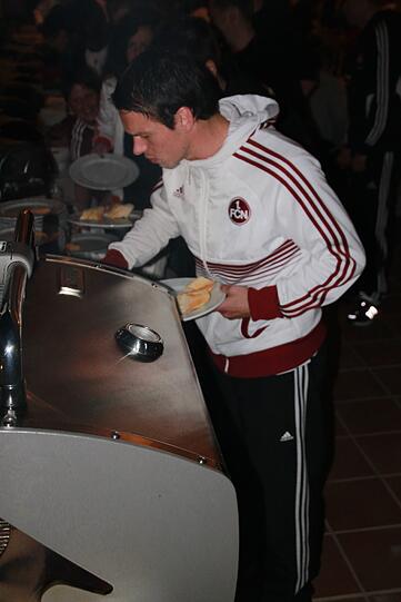 Mittelfeldspieler Markus Feulner holt sich Fleisch vom Grill.