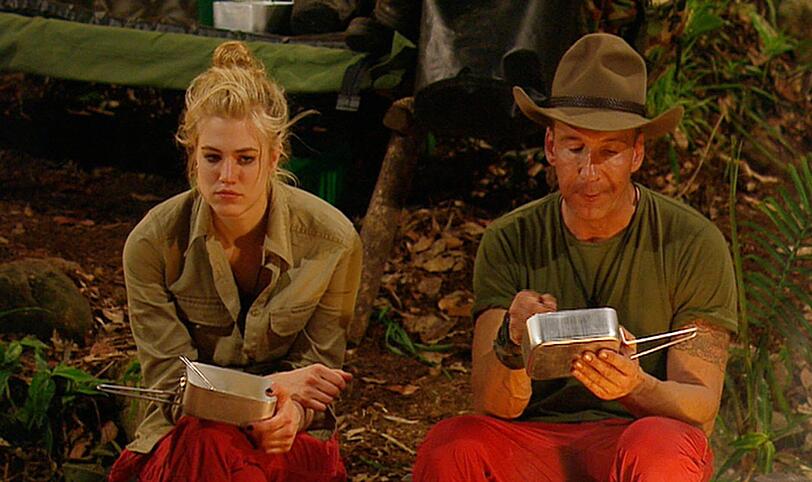 Nach zwei Stunden Marsch haben Larissa Marolt und Jochen Bendel das Camp erreicht und lassen sich das erste Essen vom Lagerfeuer - nun ja -  schmecken.