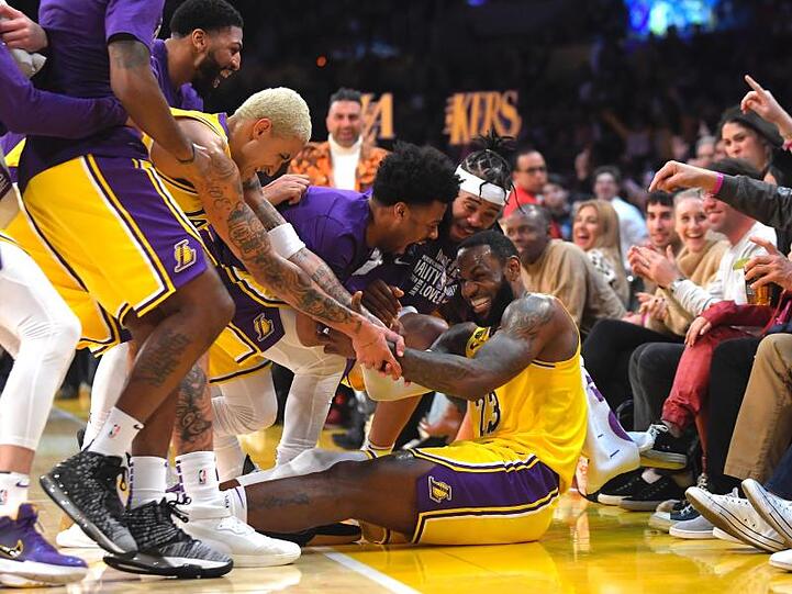 LeBron James (sitzend) wird nach mehreren erfolgreichen Drei-Punkte-Würfen für die Lakers von seinen Mitspielern bejubelt.