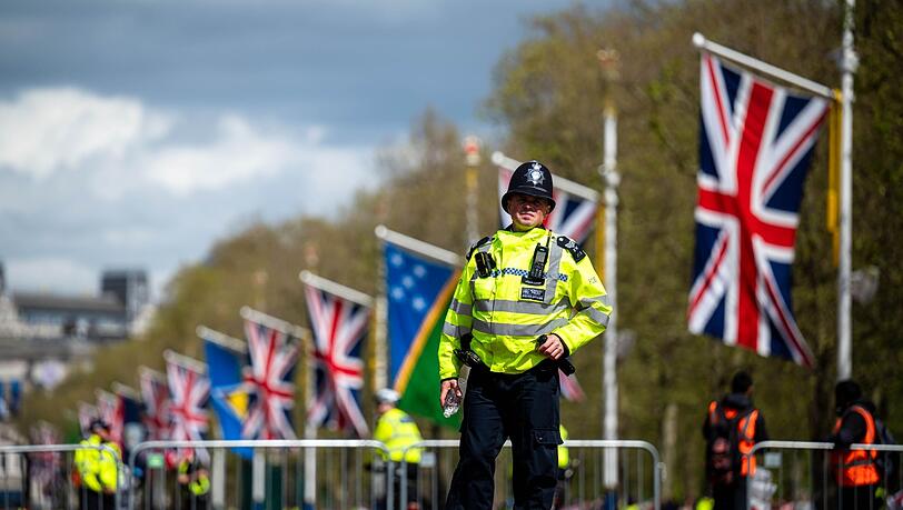 Polizisten sichern die Straße vor dem Buckingham Palace.
