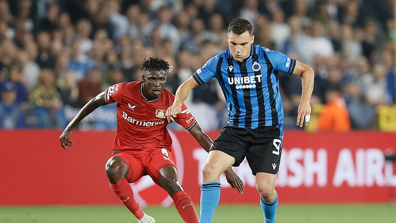 Ferran Jutgla (r) vom FC Brügge kämpft gegen Odilon Kossounou von Bayer Leverkusen um den Ballbesitz.