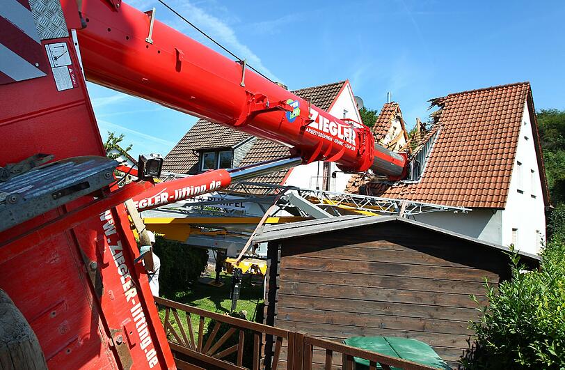 Eine Aktion, die schief ging: Als Bauarbeiter einen Kran über einen Mauer heben wollten, kippte das Fahrzeug um.