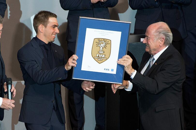 Nach dem WM-Titel gibt's von FIFA-Präsident Sepp Blatter für Nationalelf-Kapitän Lahm das FIFA-Wappen.