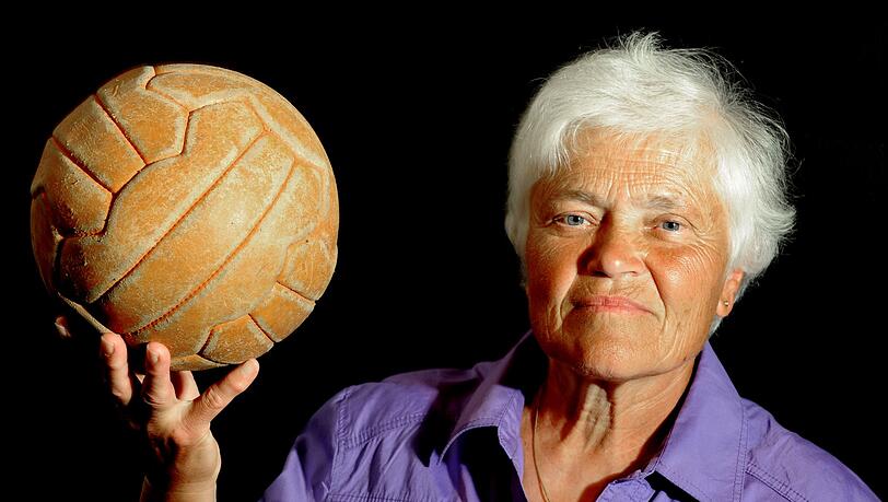 Die deutsche Frauenfußball-Pionierin Bärbel Wohlleben zeigt einen Lederball.