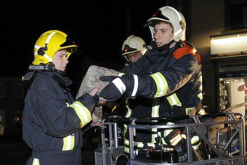 Feuerwehrmänner mit Teilen eines Schornsteins