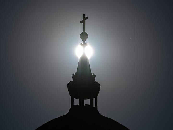 Die Sonne steht hinter der Kuppel einer Kirche. Foto: Soeren Stache/dpa-Zentralbild/ZB/Symbolbild