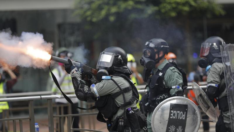 Ein Polizist setzt Tränengas gegen Demonstranten ein.