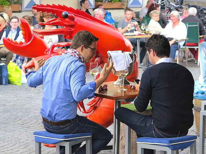 Buntes Treiben mit Weisswein trinken am Viktualienmarkt.