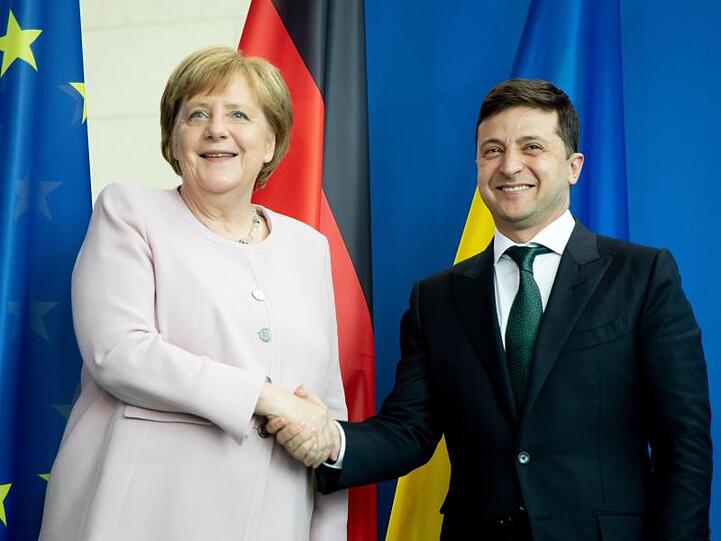 Bundeskanzlerin Angela Merkel und der ukrainische Präsident Wolodymyr Selenskyj reichen sich nach einer Pressekonferenz die Hände.
