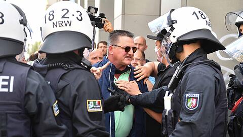 Polizisten sprechen mit einem Teilnehmer der Demonstration gegen die Corona-Maßnahmen.