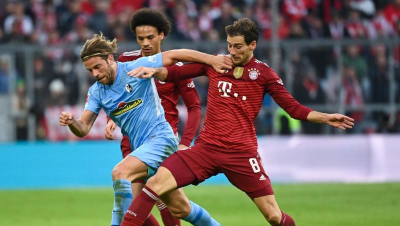 Freiburgs Lucas Höler (l) kämpft um den Ball mit Münchens Leroy Sane (hinten) und Münchens Leon Goretzka (r).