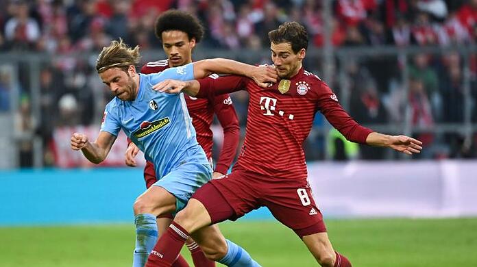 Freiburgs Lucas Höler (l) kämpft um den Ball mit Münchens Leroy Sane (hinten) und Münchens Leon Goretzka (r).