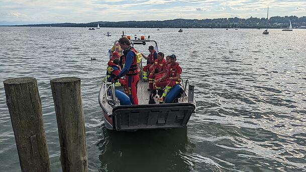 Mitglieder der Wasserwacht und der DLRG sitzen während der Suche nach einem vermissten Schwimmer am Sonntag auf einem Boot im Starnberger See.