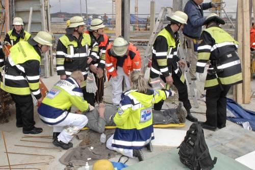 Das Feuerwehr-Notarztteam legt den Bauarbeiter in eine Rettungswanne.