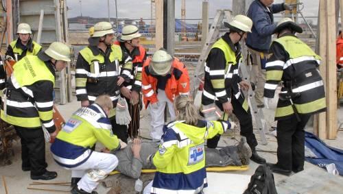 Das Feuerwehr-Notarztteam legt den Bauarbeiter in eine Rettungswanne. Das Feuerwehr-Notarztteam legt den Bauarbeiter in eine Rettungswanne.