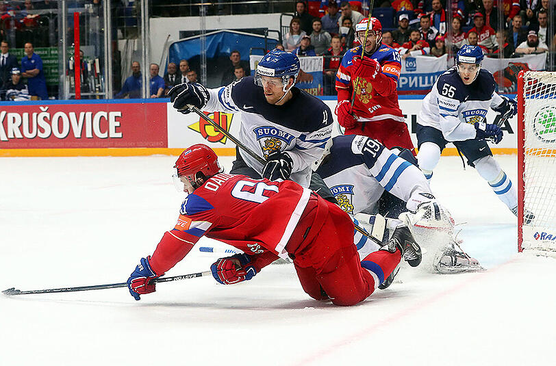 Russlands Yevgeni Dadonov (vorne) verliert im Duell mit dem Finnen Tommi Kivisto (Mitte) das Gleichgewicht.