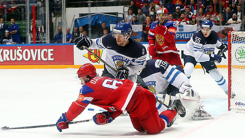 Russlands Yevgeni Dadonov (vorne) verliert im Duell mit dem Finnen Tommi Kivisto (Mitte) das Gleichgewicht. Russlands Yevgeni Dadonov (vorne) verliert im Duell mit dem Finnen Tommi Kivisto (Mitte) das Gleichgewicht.