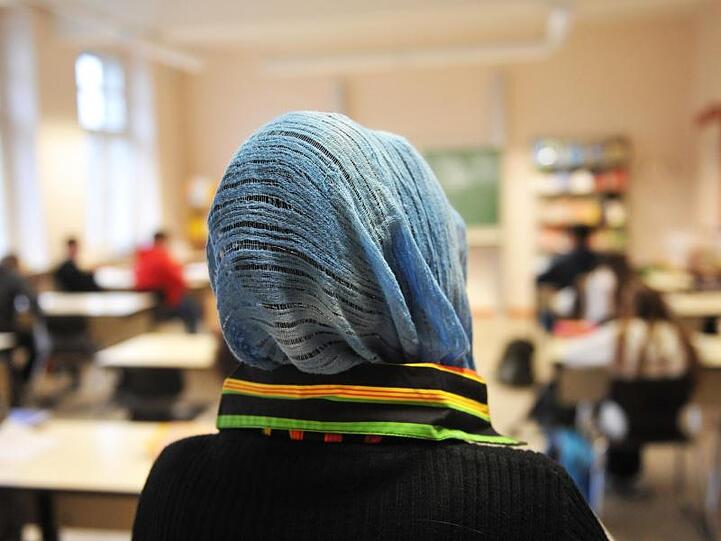 Eine Schülerin mit Kopftuch nimmt am Unterricht teil.