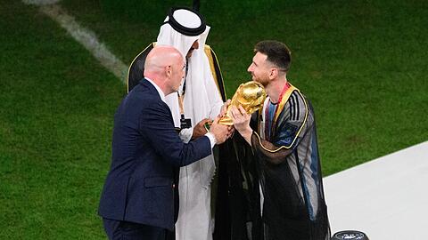 Historischer Moment: Scheich Tamim bin Hamad Al Thani (M) und  FIFA-Boss Gianni Infantino (l) übergeben Argentiniens Lionel Messi den WM-Pokal.
