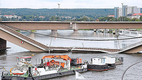 Ein Bootsanleger wird aus dem Umfeld der Carolabrücke in Dresden bewegt. Eingestürzt ist sie am Mittwochmorgen.
