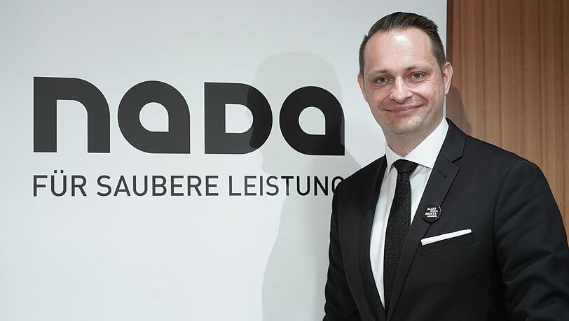 Lars Mortsiefer, Vorstand der Nationalen Anti-Doping Agentur Deutschland (NADA), steht neben dem Logo.