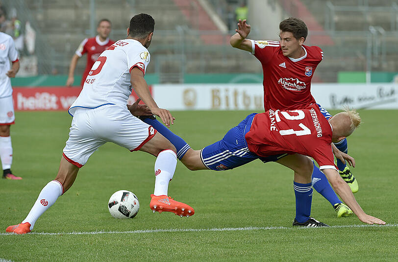 Am Ende doch gertrauchelt: Unterhachings Sascha Bigalke (M) und Jim Müller (r) im DFB-Pokal gegen Martinez Rodriguez von Mainz.