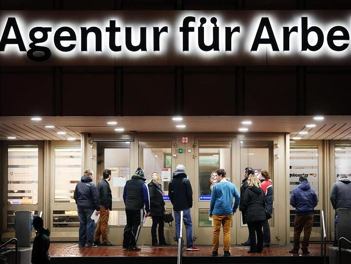 Arbeitssuchende stehen vor der Bundesagentur für Arbeit.