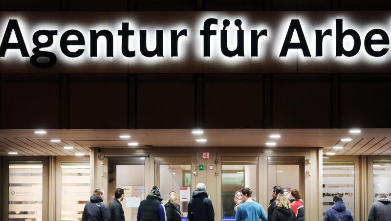 Arbeitssuchende stehen vor der Bundesagentur für Arbeit.