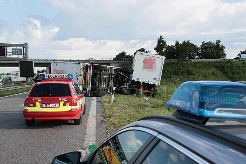 Vermutlich weil er zu schnell auf die Autobahn fährt, kommt ein Laster in der Kurve von der Fahrbahn ab und fährt in die Leitplanke. Sein Hänger kippt um.