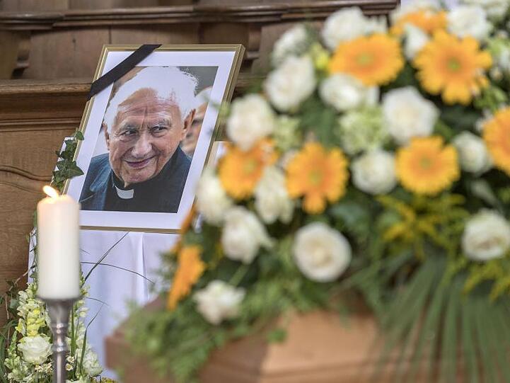 Ein Foto von Domkapellmeister Georg Ratzinger steht im Dom neben seinem Sarg. Foto: Uwe Moosburger/Bistum Regensburg/dpa/Archivbild