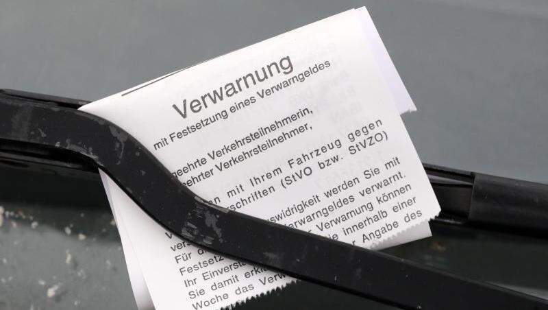Ein "Knöllchen" für einen Falschparker ist unter dessen Scheibenwischer geklemmt. Ein "Knöllchen" für einen Falschparker ist unter dessen Scheibenwischer geklemmt.