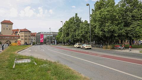 Flanieren am Isartorplatz-Park: Auf der Grünfläche links entsteht im Sommer ein temporärer Park mit Schachspiel und geschwungenen Holzliegen.