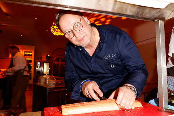 Thomas Bühner schneidet den Lachs für die geladenen Gäste.